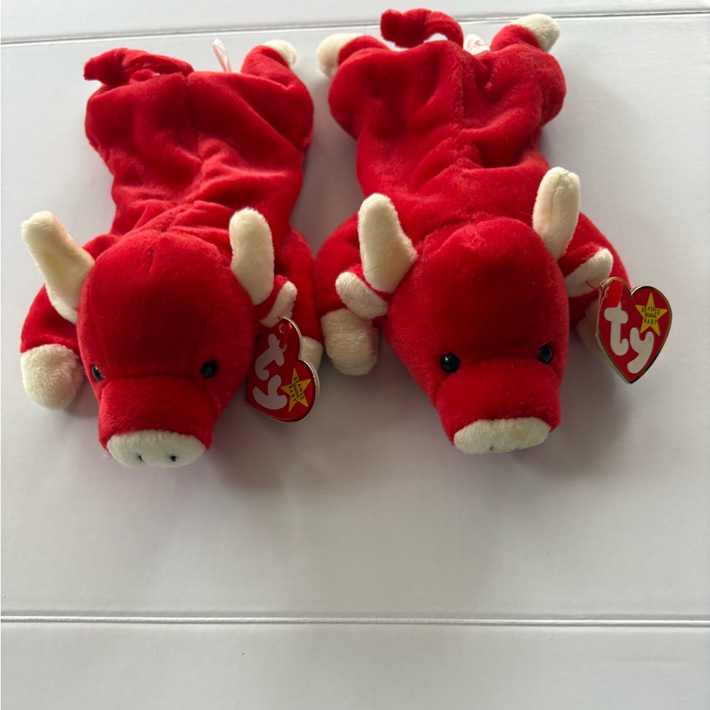 Two bull beanie babies and the color is red for both of them.